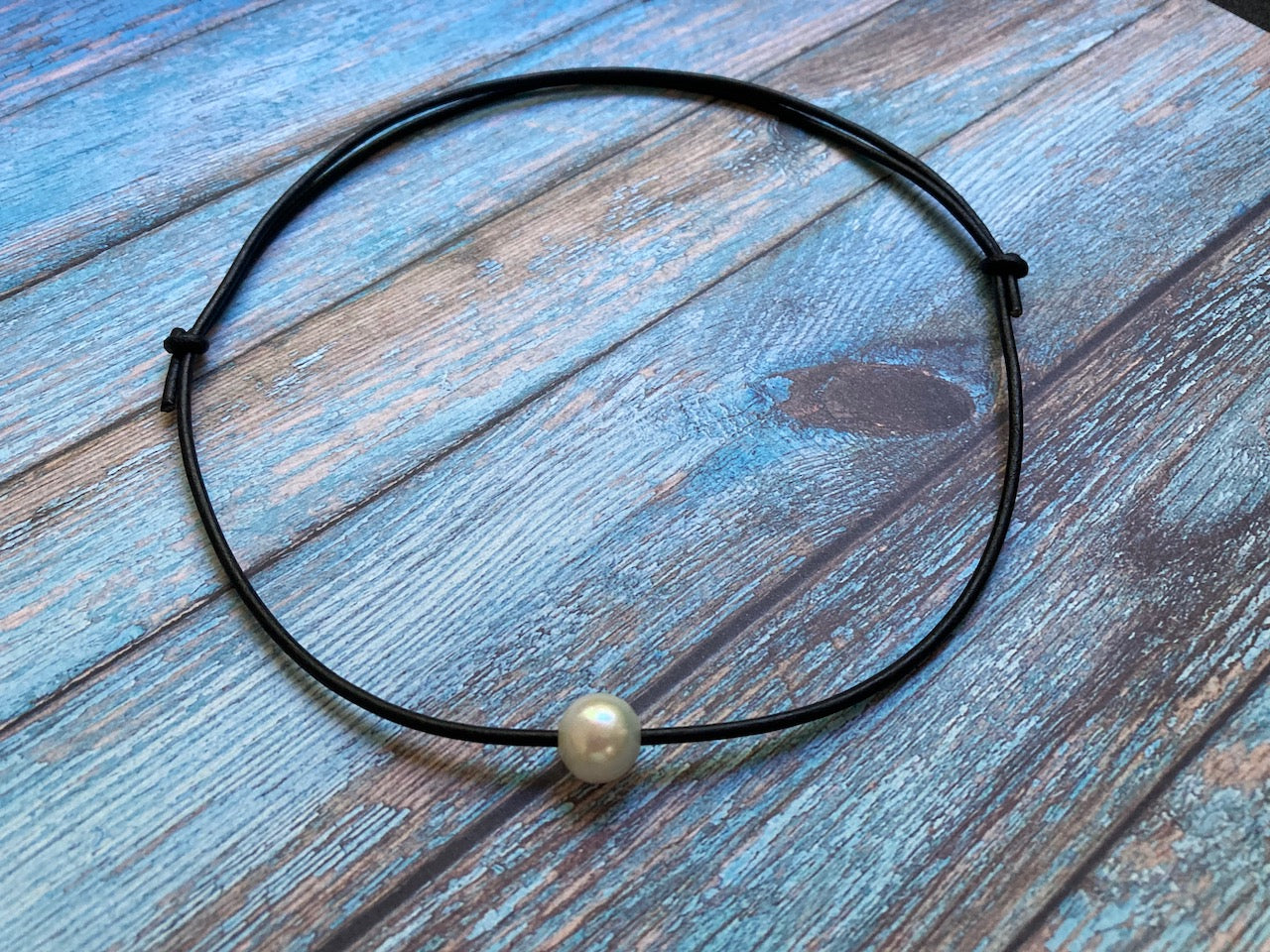 Single white freshwater pearl on black leather cord